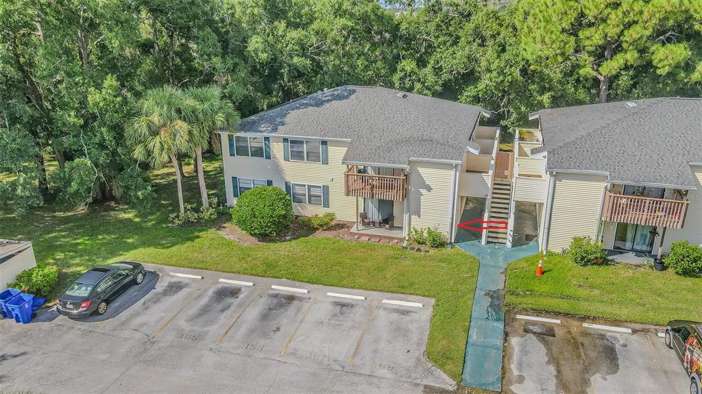 An aerial view of a two-story apartment building with a parking lot and green space — 133 SABAL COURT UNIT F, OLDSMAR, FL
