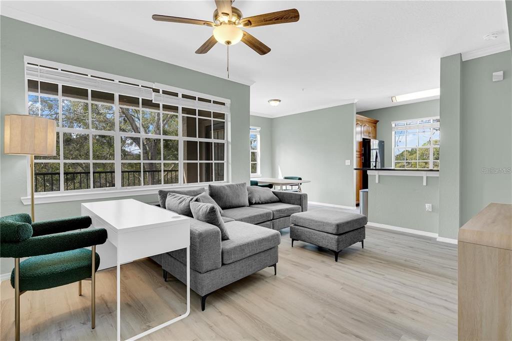 A living room features light wood floors, a gray sectional sofa, and a white desk — 2632 ROBERT TRENT JONES DRIVE UNIT 136, ORLANDO, FL