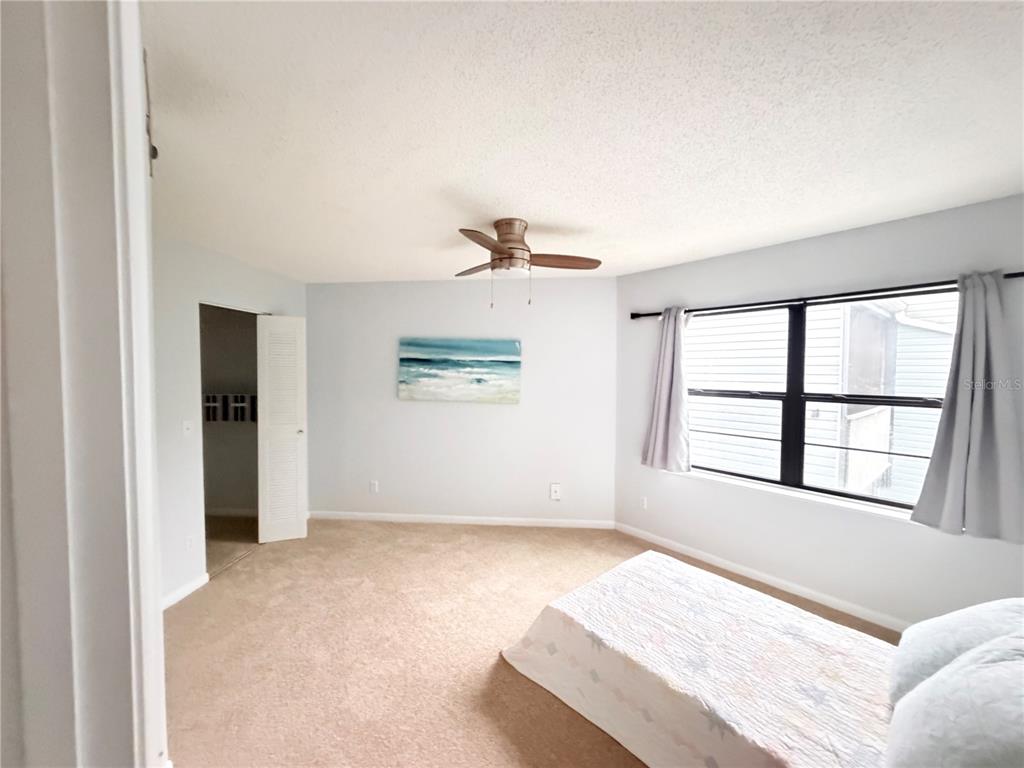 A bedroom features beige carpeting, a ceiling fan, a window with curtains, and a bed — 3914 ATRIUM DRIVE bldg36, ORLANDO, FL