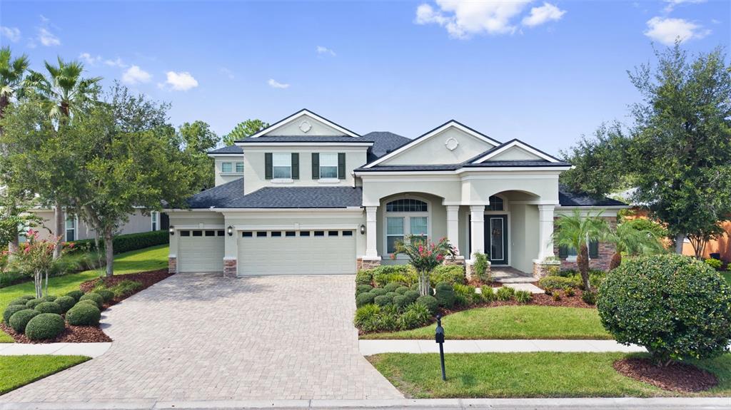A two-story suburban house features a paved driveway, a three-car garage, and a covered entryway — 27816 COBALT LANE, WESLEY CHAPEL, FL