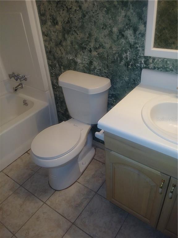 A bathroom features a white toilet, a vanity with a sink, and a bathtub shower — 902 LAKE DESTINY ROAD UNIT B, ALTAMONTE SPRINGS, FL