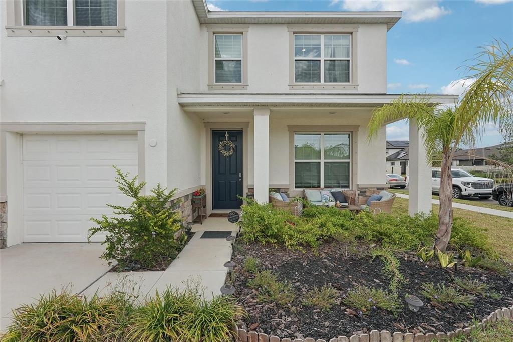 A two-story house exterior features a white stucco facade, a garage, and a front porch — 13055 WILLOW GROVE DRIVE, RIVERVIEW, FL