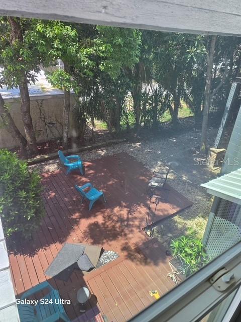 An elevated view shows a wooden deck with several chairs and a gravel yard — 7306 EARLWOOD AVENUE UNIT 5, MOUNT DORA, FL