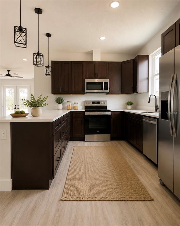 A kitchen features dark wood cabinets, stainless steel appliances, white countertops, and a woven rug — 5541 MOONGATE ROAD, SPRING HILL, FL