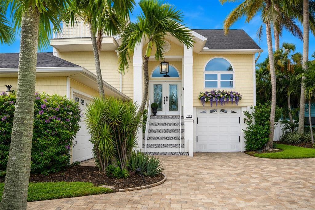 A white exterior pillar displays a house number above stairs with patterned blue-and-white tiles — 255 46TH AVENUE, ST PETE BEACH, FL