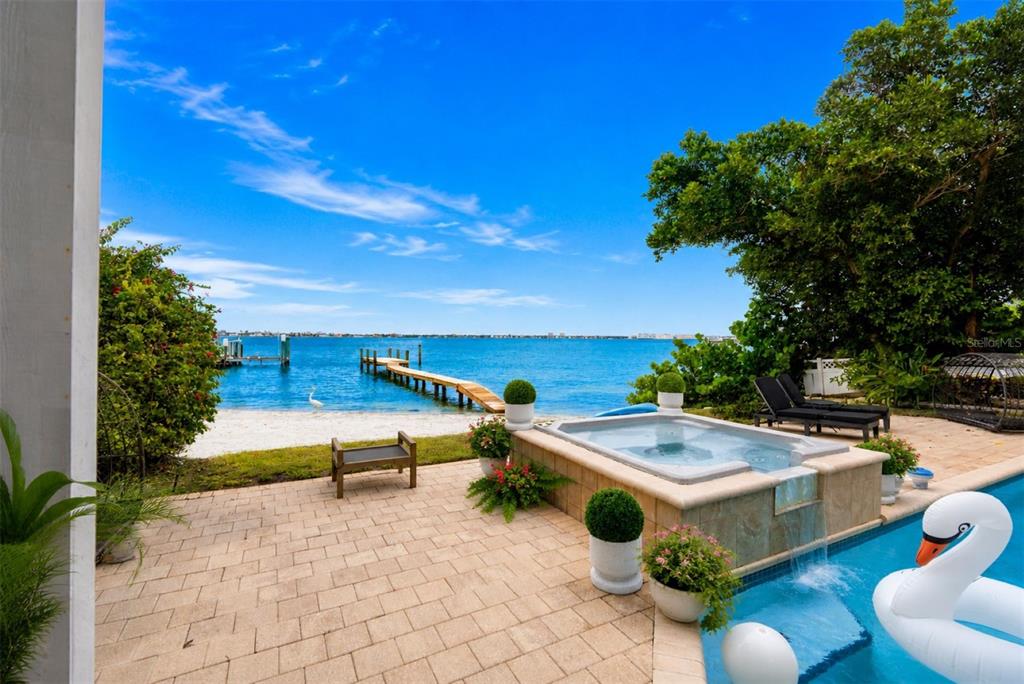A multi-story house with a pool, patio, and illuminated balconies at dusk — 255 46TH AVENUE, ST PETE BEACH, FL