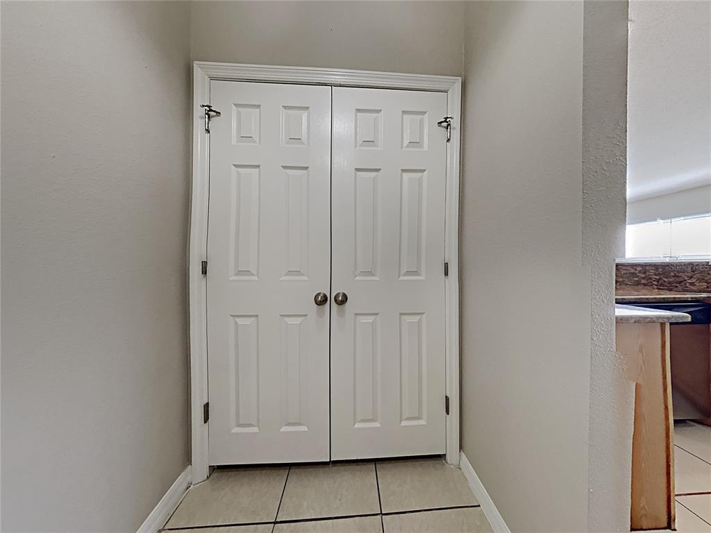 A set of white six-panel double doors is centered between two beige walls — 1322 DRAGON HEAD DRIVE, VALRICO, FL