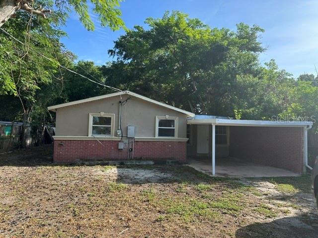 A single-story house with a brick base, stucco walls, and an attached carport — 3915 AVENUE Q NW, WINTER HAVEN, FL