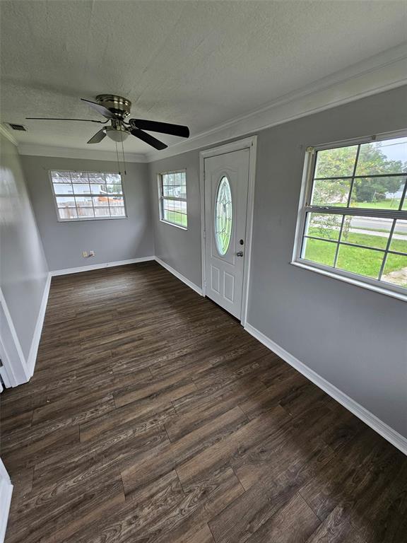 A galley kitchen features wood cabinets, white appliances, a window, and light-colored tile flooring — 220 DIXIE HIGHWAY, AUBURNDALE, FL
