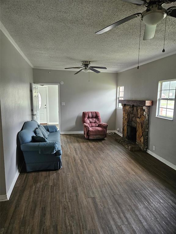 A living room features a stone fireplace, wood-look flooring, a ceiling fan, and assorted furniture — 220 DIXIE HIGHWAY, AUBURNDALE, FL