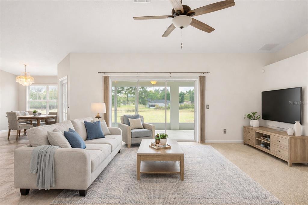 A living room features a beige sofa, a coffee table, and a television on a console — 4910 SW 109TH LOOP, OCALA, FL