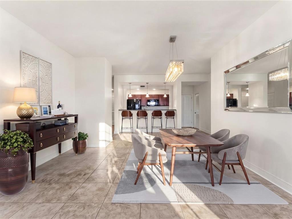 A dining area with a wooden table, grey chairs, and a console table on tile flooring — 628 CLEVELAND STREET UNIT 1211, CLEARWATER, FL