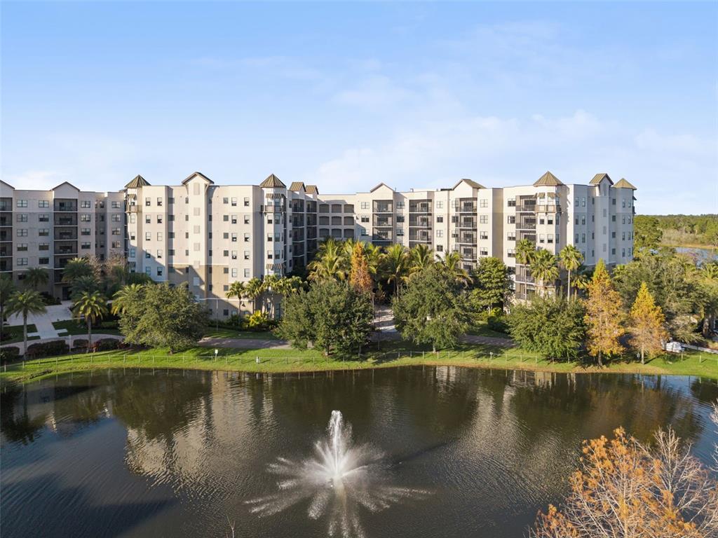 A living and dining area features a sofa, glass tables, a television, and large windows — 14501 GROVE RESORT AVENUE UNIT 1111, WINTER GARDEN, FL