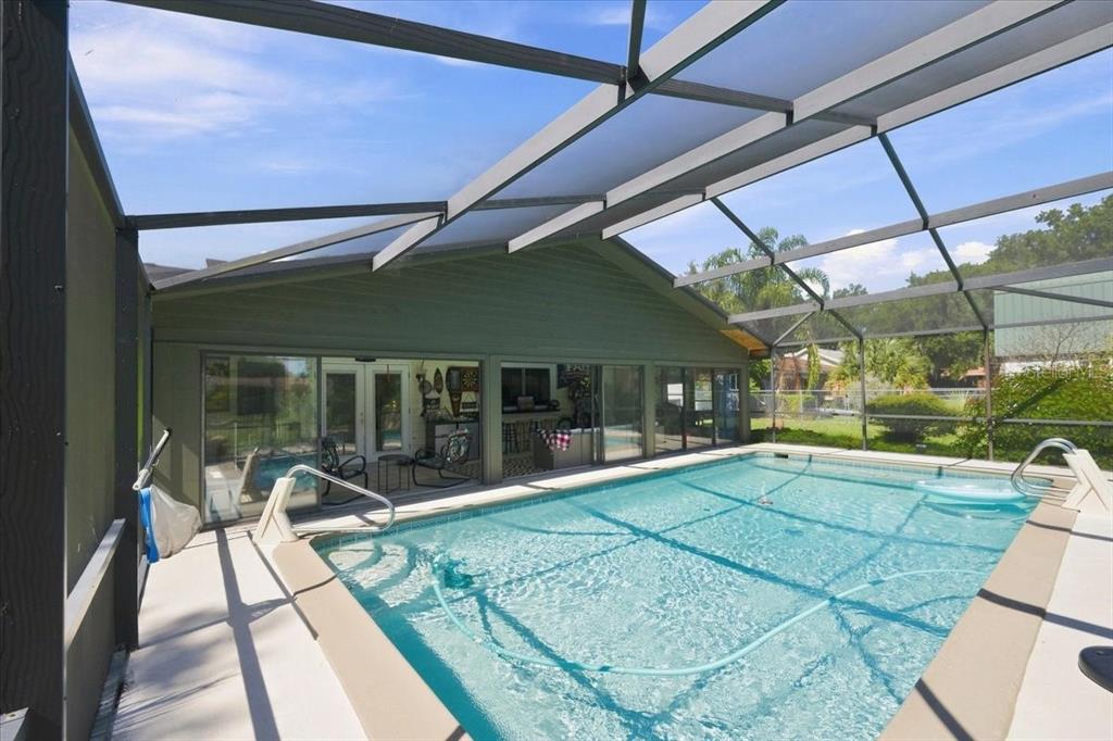 A swimming pool is enclosed by a screened lanai attached to the back of a house — 4475 OLD COLONY ROAD, MULBERRY, FL