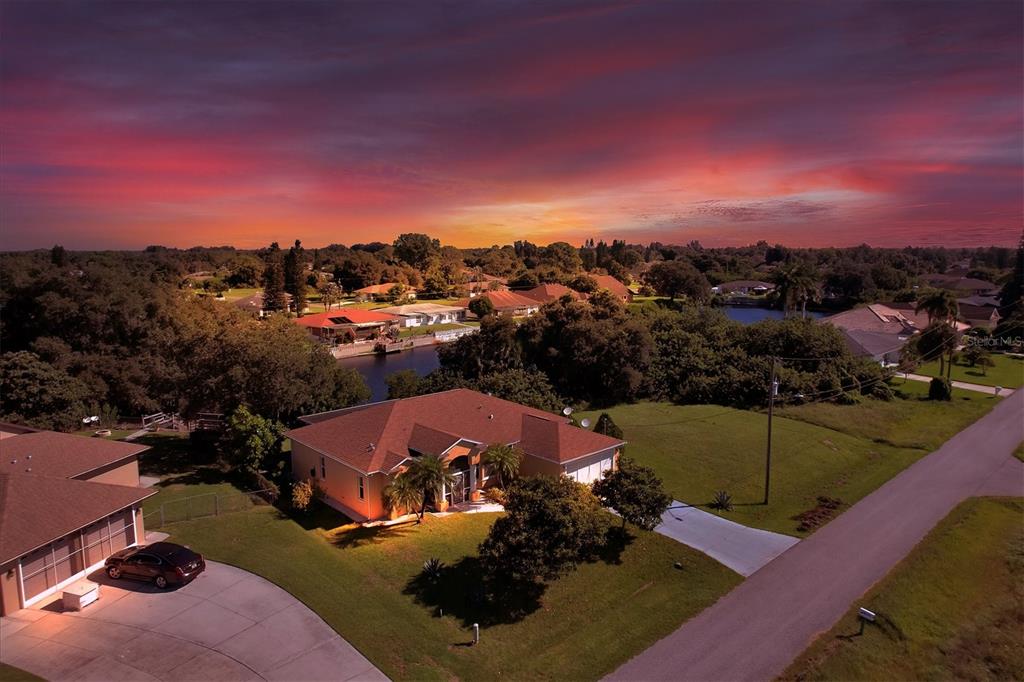 An aerial view of a suburban house with a brown roof at sunset — 12004 SARTO LANE, NORTH PORT, FL