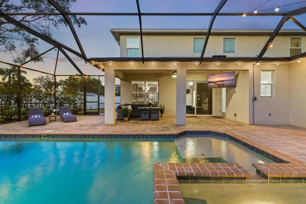 A covered patio with a pool and spa is enclosed by a screened-in lanai — 2930 W ROGERS AVENUE, TAMPA, FL