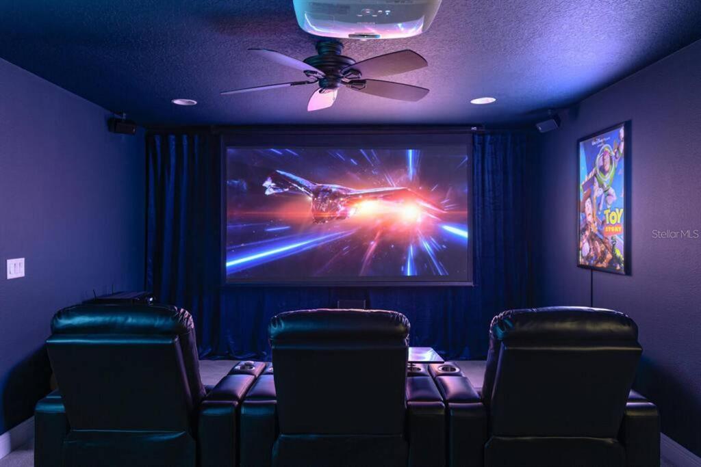 A home theater room features three black leather recliners, a projector, and a large screen — 2930 W ROGERS AVENUE, TAMPA, FL