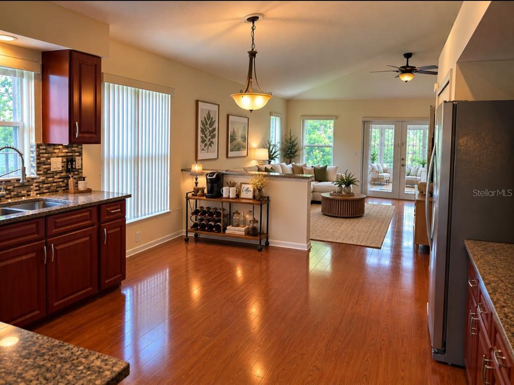 A kitchen features dark wood cabinets, granite countertops, a tiled backsplash, and hardwood flooring — 924 RIDGE HAVEN DRIVE, BRANDON, FL