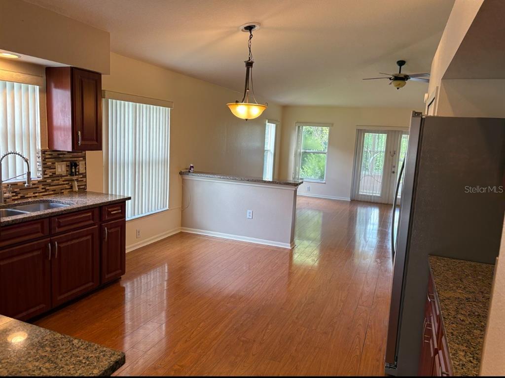 A kitchen features a stainless steel refrigerator, dark wood cabinets, and a tiled backsplash — 924 RIDGE HAVEN DRIVE, BRANDON, FL