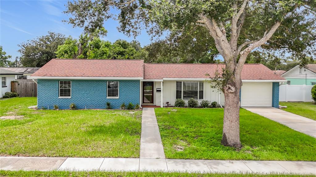 A single-story house with a blue brick facade, white siding, and a large front tree — 514 W HILDA DRIVE, BRANDON, FL