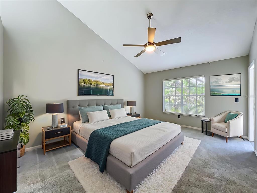A bedroom features a gray upholstered bed, a ceiling fan, and a large window — 248 WIMBLEDON CIRCLE UNIT 248, LAKE MARY, FL