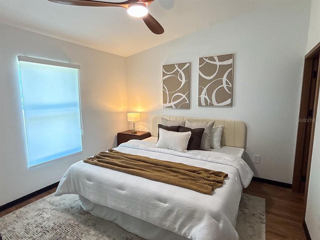 A modern kitchen features white cabinets, stone countertops, and wood-look flooring — 5620 VIRTUDES STREET, SEBRING, FL