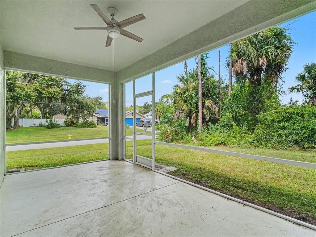 A screened-in concrete patio features a ceiling fan and views of a grassy yard — 4288 DUREVE AVENUE, NORTH PORT, FL
