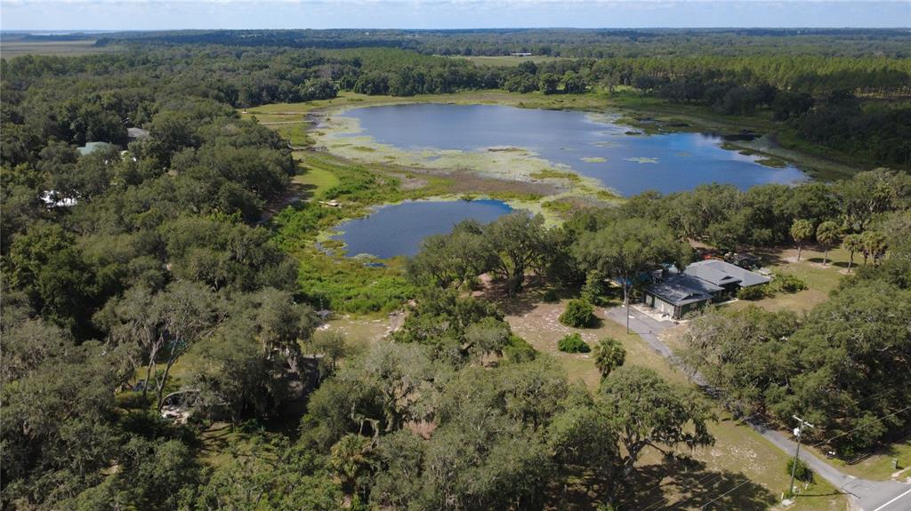 An aerial view of a house situated on a large lot beside a lake — SE HWY 42, WEIRSDALE, FL