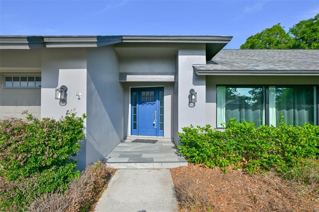 A single-story house with a gray exterior, a two-car garage, and a blue front door — 2701 HERNDON STREET, VALRICO, FL