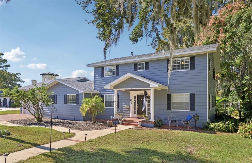 A foyer features hardwood floors, a carpeted staircase with a wooden railing, and arched doorways — 1105 S 9TH STREET, LEESBURG, FL