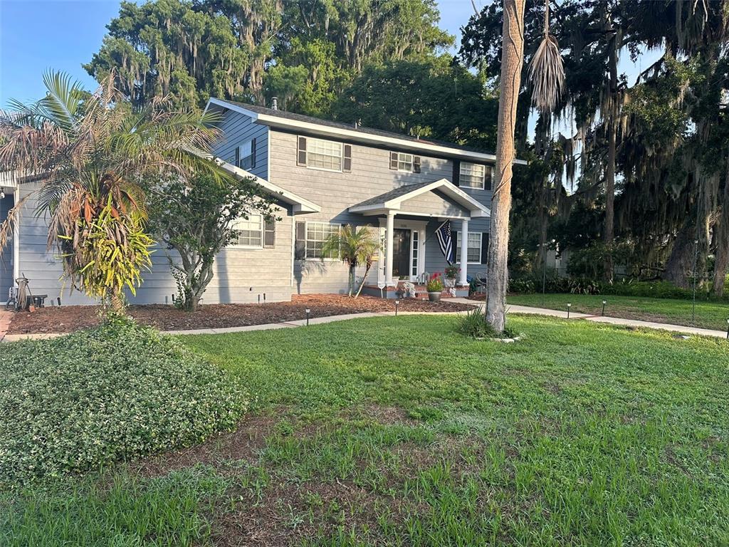 A dining room features a table with a patterned cloth, wood furniture, and green walls — 1105 S 9TH STREET, LEESBURG, FL