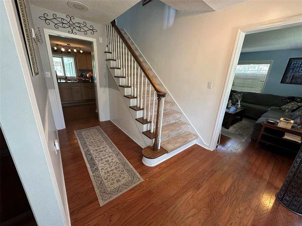 A living room features a sectional sofa, a coffee table, and a television on a stand — 1105 S 9TH STREET, LEESBURG, FL