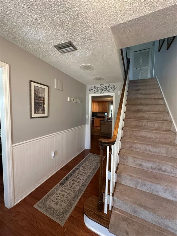 A living room features a grey sectional sofa, a coffee table, and large black bookshelves — 1105 S 9TH STREET, LEESBURG, FL
