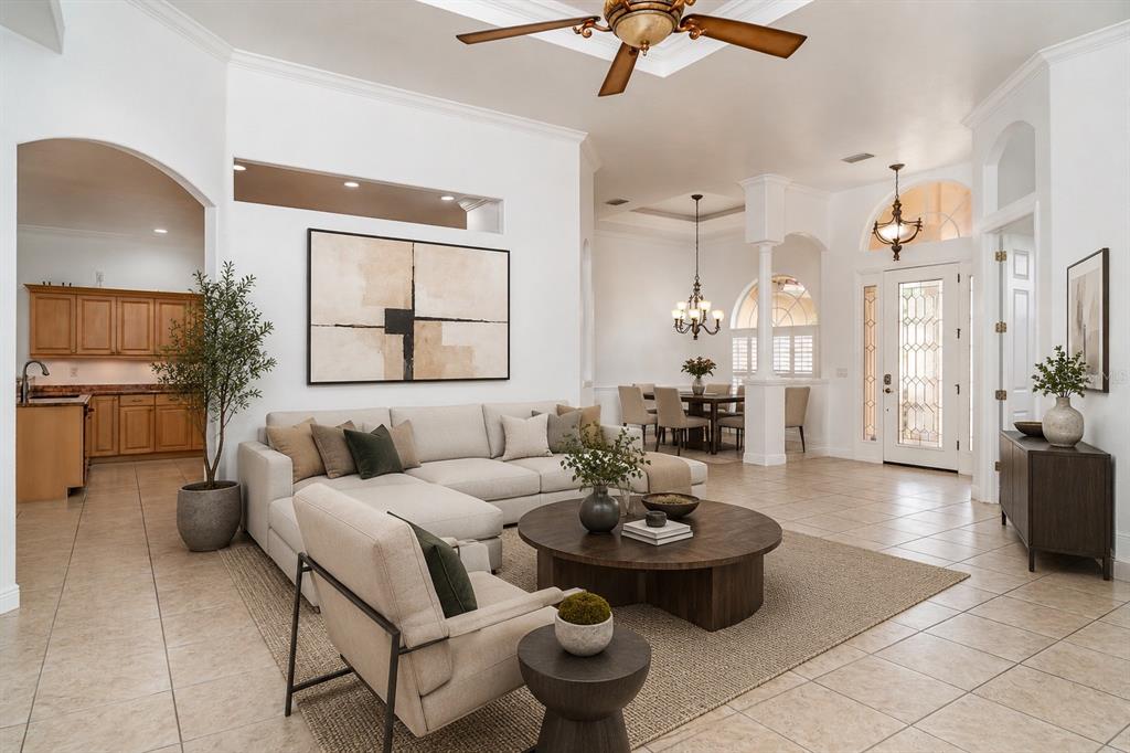 A bright, open-concept living room features tile flooring, a sectional sofa, and a dining area — 6120 9TH AVENUE CIRCLE NE, BRADENTON, FL
