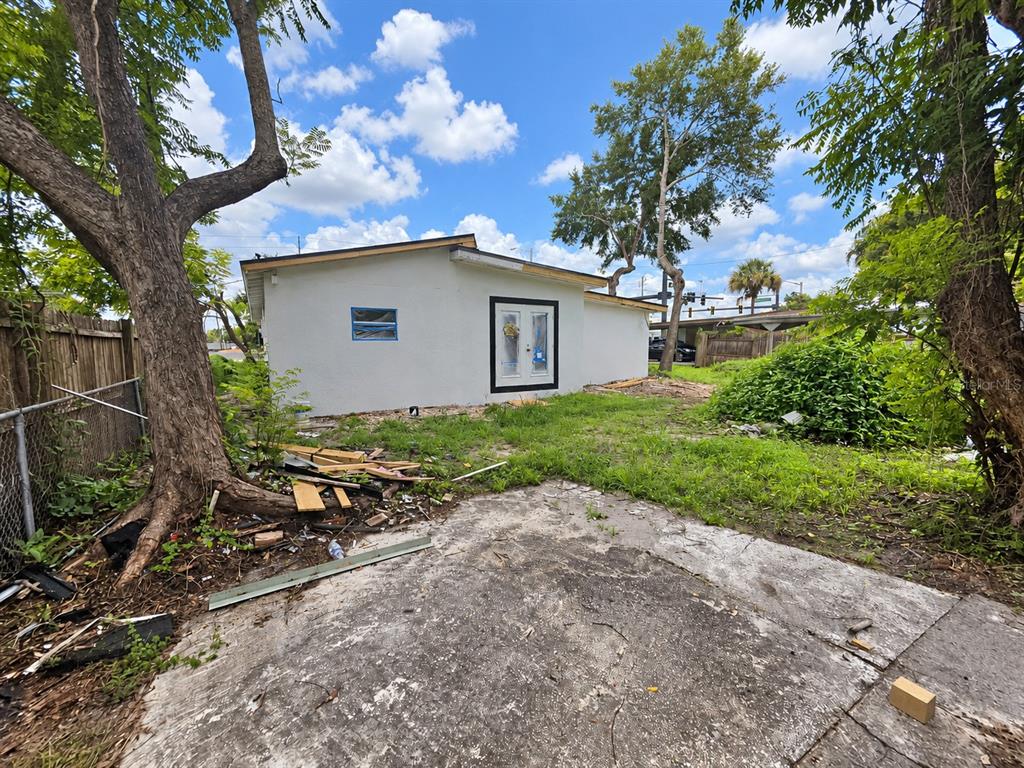 An unfinished interior room features exposed ceiling joists, concrete floors, and bare wall panels — 1024 W FAIRBANKS AVENUE, ORLANDO, FL