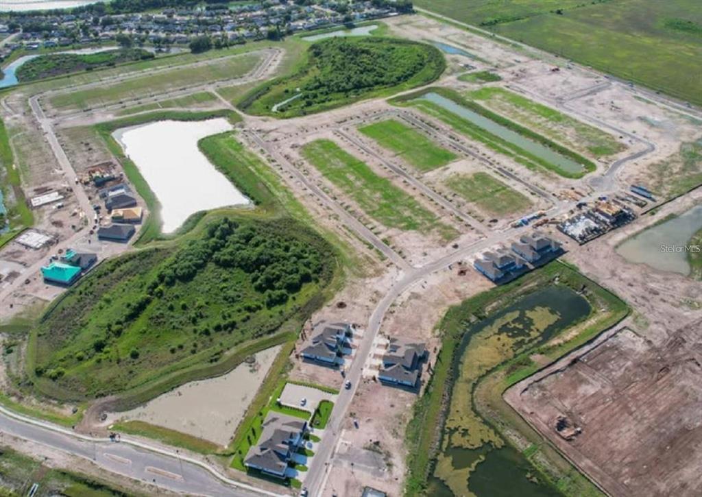 An aerial view shows a new residential development under construction with several completed houses — 7827 GLEN LILY PLACE, PARRISH, FL