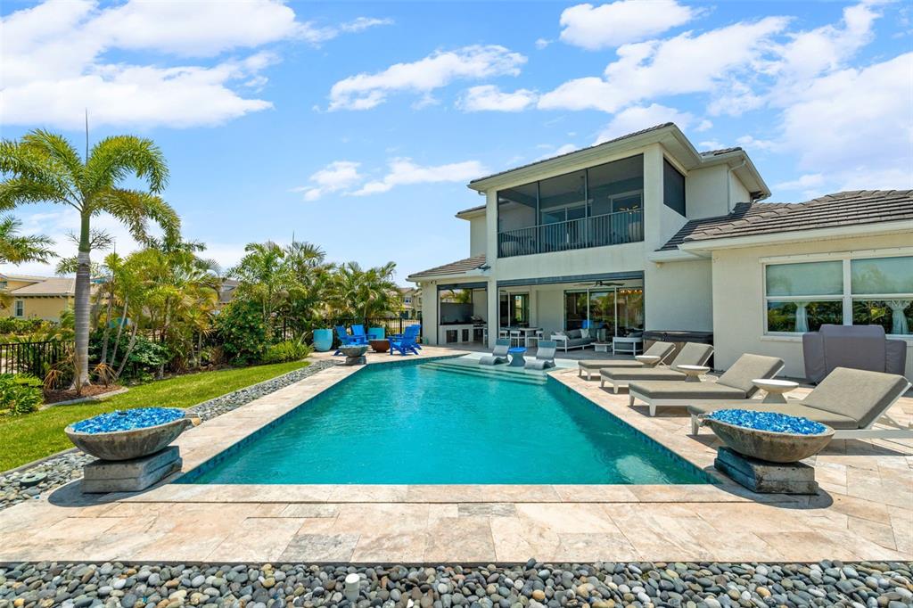 A two-story house with a screened balcony overlooks a rectangular swimming pool and patio — 1256 TYNE LANE, BRADENTON, FL