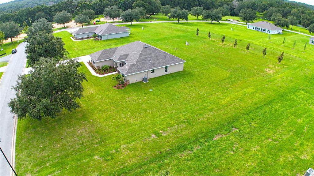 A single-story house with a tan stucco exterior and a gray shingled roof — 37094 HIDDEN VIEW CIRCLE, DADE CITY, FL