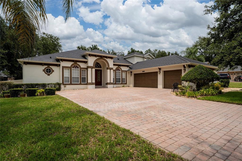 A single-story house with a paved driveway, arched entryway, and a two-car garage — 6230 BORDEAUX CIRCLE, SANFORD, FL