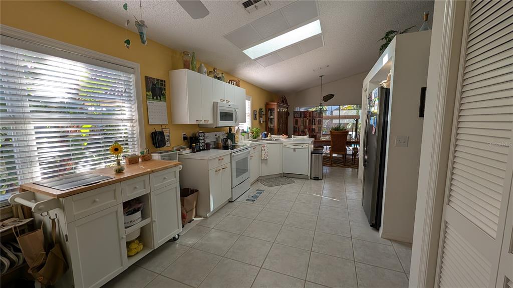 A living room features a brown sofa, a beige armchair with ottoman, and a television — 5406 83RD TERRACE E, SARASOTA, FL