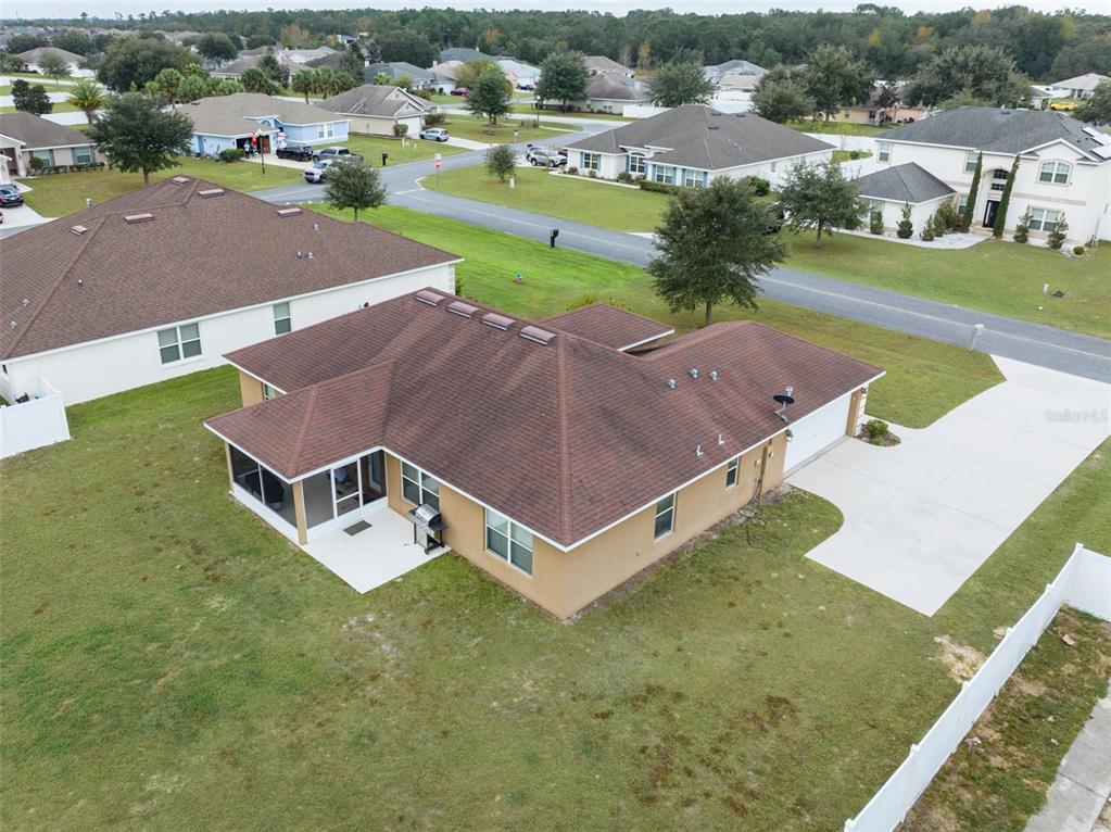 An aerial view of a tan single-story house with a brown roof and screened patio — 5749 SW 98TH PLACE, OCALA, FL