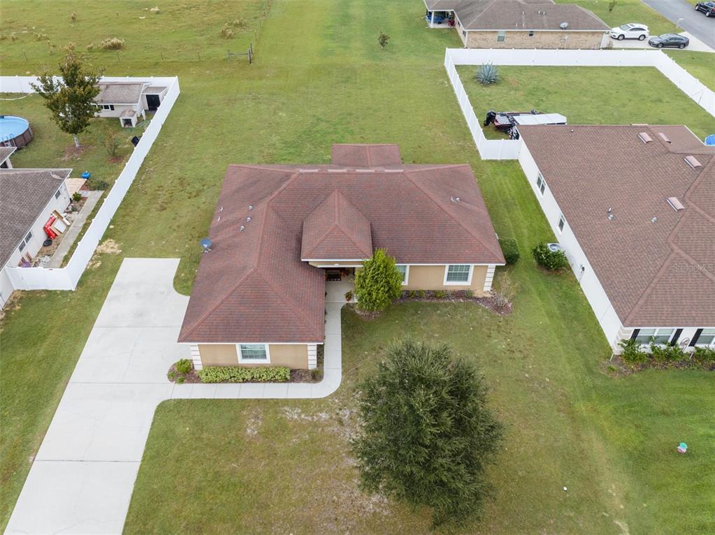An aerial view shows a single-story house with a brown roof and a concrete driveway — 5749 SW 98TH PLACE, OCALA, FL