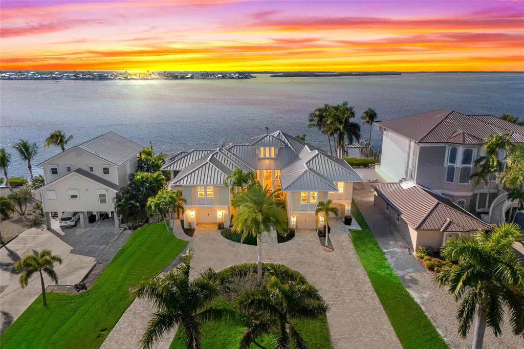 An aerial view of a waterfront house with a metal roof and paved driveway — 12271 SHOREVIEW DRIVE, MATLACHA, FL