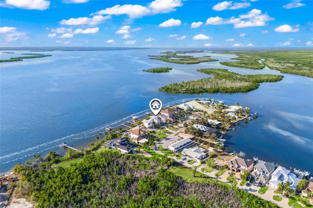 An aerial view shows waterfront homes situated on a peninsula surrounded by a large bay — 12271 SHOREVIEW DRIVE, MATLACHA, FL