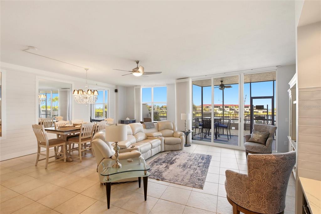 A bright living and dining area features tile floors, a sectional sofa, and sliding doors — 3313 SUNSET KEY CIRCLE UNIT 105, PUNTA GORDA, FL
