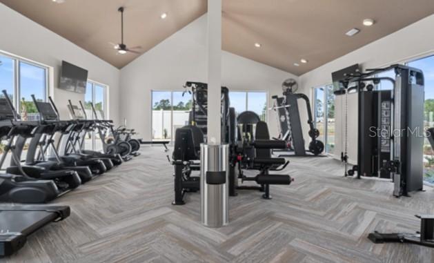 A bright gym features various exercise machines, large windows, and a patterned tile floor — 5692 STEPHENS ROAD, ST CLOUD, FL
