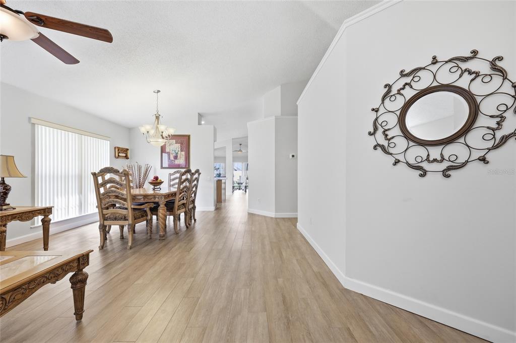 A dining area with wood-look flooring, a chandelier, and a decorative mirror on the wall — 115 N WEATHERSFIELD AVENUE, ALTAMONTE SPRINGS, FL