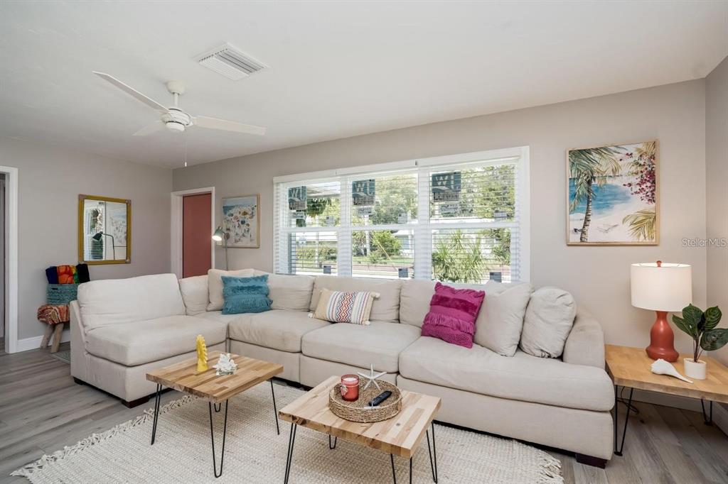 A living room features a large beige sectional sofa, two wooden coffee tables, and light flooring — 617 26TH STREET W, BRADENTON, FL