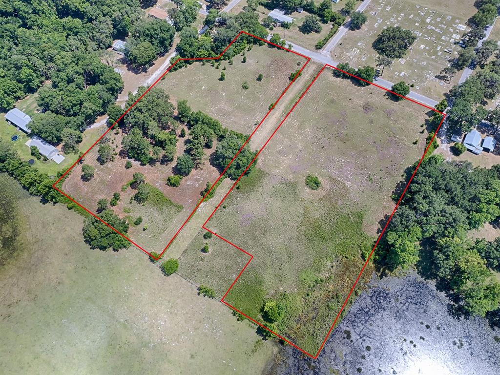 An aerial view shows two adjacent, mostly cleared lots outlined in red near a lake — TBD E PARK STREET, CENTER HILL, FL