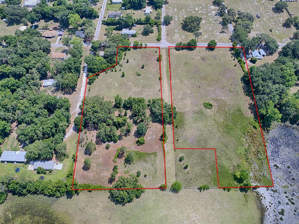 An aerial view shows two adjacent vacant lots outlined in red near a road and cemetery — TBD E PARK STREET, CENTER HILL, FL